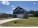 Well-manicured two-story home with blue siding, two car garage, and lush green lawn at 172 Knoll Way, Sanford, NC 27332