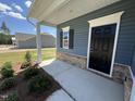 Inviting front porch featuring brick accents, white trim, and a black front door at 172 Knoll Way, Sanford, NC 27332