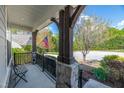 Inviting front porch with wooden pillars, stone accents, and a cozy bench at 2008 Stanwood Dr, Apex, NC 27502