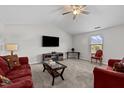 Cozy living room with plush red sofas, a ceiling fan, a large window and vaulted ceilings at 2040 Alderman Way, Creedmoor, NC 27522
