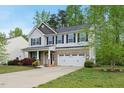 Attractive two-story house featuring gray siding, black shutters and a two-car garage at 226 Fair Oaks Ct, Mebane, NC 27302