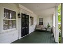 Covered front porch with a black door, stylish lighting, and comfortable seating, creating a welcoming entrance at 2415 Van Dyke Ave, Raleigh, NC 27607