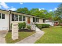 Beautiful single-story home with brick pillar, walkway, well-maintained lawn, and a lovely orange front door at 2712 Cameron Dr, Sanford, NC 27332