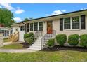 Inviting entrance with a brick facade, black shutters, and a warm-toned front door at 2712 Cameron Dr, Sanford, NC 27332