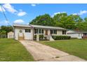 This single-story home boasts a well-kept lawn, updated metal roof, and charming orange front door at 2712 Cameron Dr, Sanford, NC 27332