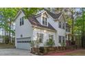 Angle shot of the white home highlighting the garage, trimmed flower bed, and brick stairs at 286 Trillium Way, Clayton, NC 27527