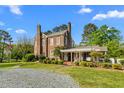 Attractive brick home with a covered porch and patio area, set in a lush green yard at 3542 Bason Rd, Mebane, NC 27302