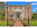 Charming brick home with a welcoming front porch, lampposts, and manicured landscaping at 3542 Bason Rd, Mebane, NC 27302