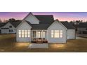 Back exterior view of a house featuring white siding, lots of windows, and a wooden porch at 3941 Wendell Blvd, Wendell, NC 27591