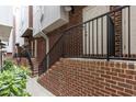 Brick townhome entrances with black railings and landscaped walkway at 400 W Rosemary St # 104, Chapel Hill, NC 27516