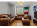 Comfortable living room with hardwood floors, leather sofas, and natural light from the window at 400 W Rosemary St # 104, Chapel Hill, NC 27516