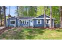 Inviting blue home with white trim, a light blue door, and manicured lawn at 403 Mayodan Dr, Cary, NC 27511