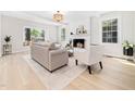 Cozy living room featuring neutral furniture, a brick fireplace, and light wood floors at 403 Mayodan Dr, Cary, NC 27511