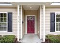 Close-up of the home's front door, showing the maroon door, black shutters and manicured landscaping at 411 A Aversboro Rd, Garner, NC 27529