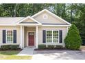 Charming single story home with tan siding, black shutters, a red door, and attractive landscaping at 411 B Aversboro Rd, Garner, NC 27529