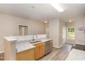 Open kitchen with light wood cabinets, granite counters, stainless dishwasher and luxury vinyl plank flooring at 411 B Aversboro Rd, Garner, NC 27529