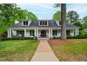 Charming white brick home featuring a welcoming front porch, perfect for relaxing and enjoying the outdoors at 4237 Rowan St, Raleigh, NC 27609