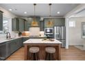Modern kitchen with island, stylish pendant lights, stainless steel appliances, and custom cabinets at 536 Folk Song Way, Wendell, NC 27591