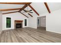 Spacious living room featuring wood beam ceilings, a stone fireplace, and hardwood floors at 5604 Groomsbridge Ct, Raleigh, NC 27612