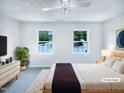 Bright bedroom featuring large windows with water views, neutral walls, and carpet at 5828 Brambleton Ave, Raleigh, NC 27610