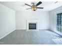 Cozy living room featuring fireplace, neutral walls, carpet, and a ceiling fan at 5828 Brambleton Ave, Raleigh, NC 27610