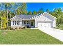 Charming single-story home with a manicured lawn and attached two-car garage at 61 Okra Ct, Selma, NC 27576