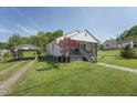 Exterior view of home featuring lawn, carport, and beautiful landscaping at 729 S Carolina Ave, Henderson, NC 27536
