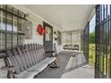 Cozy front porch with a comfortable bench and swing at 729 S Carolina Ave, Henderson, NC 27536