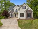 Beautifully landscaped two-story home boasting a mix of neutral siding and brick accents, enhancing its curb appeal at 733 Holding Ridge Ct, Wake Forest, NC 27587