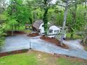 Aerial view of the home showing the home's serene, private wooded lot, circular drive, and covered outdoor space at 831 Healey Ln, Durham, NC 27705