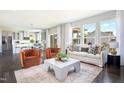 Bright living room featuring an open floor plan, a plush sofa, and large windows at 900 Emmer St, Rolesville, NC 27571