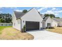 Angle shot of the white craftsman-style home showing the garage and landscaping at 1008 Peedin Rd, Selma, NC 27576