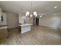 Open floor plan of kitchen with island, hardwood floors and modern chandelier lighting at 1008 Peedin Rd, Selma, NC 27576