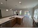 Bright kitchen with a center island and view of the fireplace and hardwood floors of the living area at 1008 Peedin Rd, Selma, NC 27576