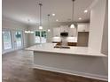 Kitchen with granite counters, pendant lights, stainless appliances, and view of the living room at 1008 Peedin Rd, Selma, NC 27576