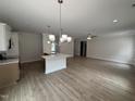 Open-concept living room with a kitchen island, wood-look flooring, and neutral decor at 1008 Peedin Rd, Selma, NC 27576