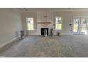 Sunlit living area with a cozy fireplace, and large windows, offering a warm and inviting atmosphere at 1008 Peedin Rd, Selma, NC 27576
