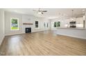 Spacious open floor plan featuring light wood-look floors, fireplace, and bright kitchen at 1008 Peedin Rd, Selma, NC 27576
