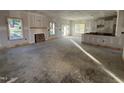 Large living room area with lots of natural light, fireplace, and kitchen area nearby at 1008 Peedin Rd, Selma, NC 27576