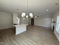 Open-concept living area featuring wood floors and elegant lighting at 1008 Peedin Rd, Selma, NC 27576