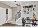 Inviting entryway featuring wood floors and staircase with an iron handrail, complemented by stylish decor at 1016 Leatherstone Ln, Fuquay Varina, NC 27526