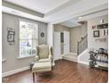 Cozy living room featuring stylish chair, wood floors, and staircase to the second floor at 1016 Leatherstone Ln, Fuquay Varina, NC 27526