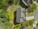 A high-angle, eye-level view of a house with lush landscaping and a wooden deck at 112 Natchez Ct, Cary, NC 27519