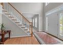 Bright foyer featuring hardwood floors, staircase, large windows, and a white front door at 112 Natchez Ct, Cary, NC 27519