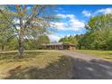 Brick ranch home with long driveway and mature trees in a lush green setting at 1213 Walnut St, Cary, NC 27511