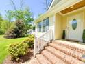 Inviting front porch with brick steps, white railings, and a decorative glass front door at 122 American Rd, Timberlake, NC 27583