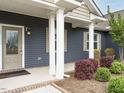 Inviting front porch with white columns and landscaped garden at 125 Claymore Dr, Clayton, NC 27527