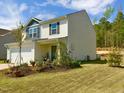 Two-story home with white siding, blue accents, landscaping, and a well-maintained lawn against a sunny blue sky at 135 Shallow Dr, Youngsville, NC 27596