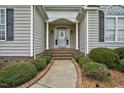 Welcoming front entrance with a decorative glass door and elegant sidelights at 1454 Spring Pond Rd, Nashville, NC 27856