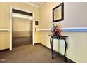Hallway view featuring a clean elevator entrance and a decorative flower arrangement on a table at 1521 Providence Glen Dr # 1521, Chapel Hill, NC 27514